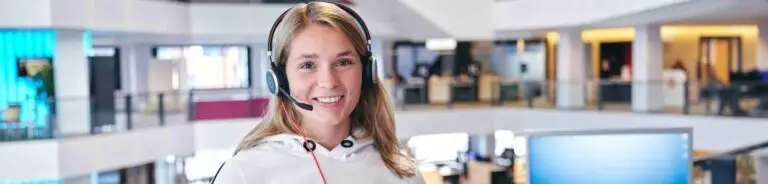 Glimlachende administratief medewerker met headset op kantoor
