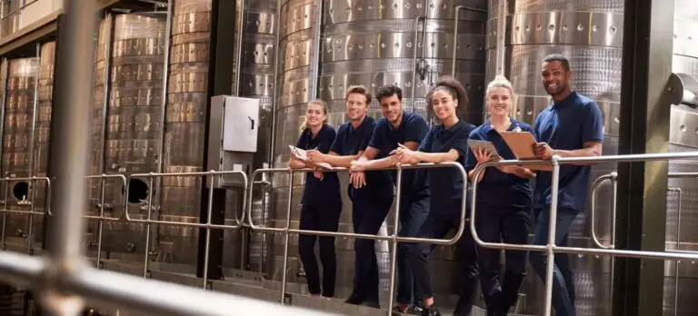 Team productiemedewerkers in werkkleding in een fabriekshal