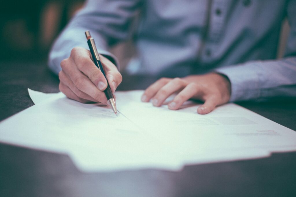 Iemand ondertekent een arbeidscontract met een pen