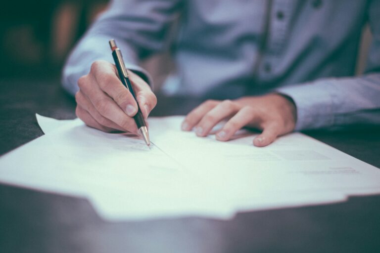 Iemand ondertekent een arbeidscontract met een pen